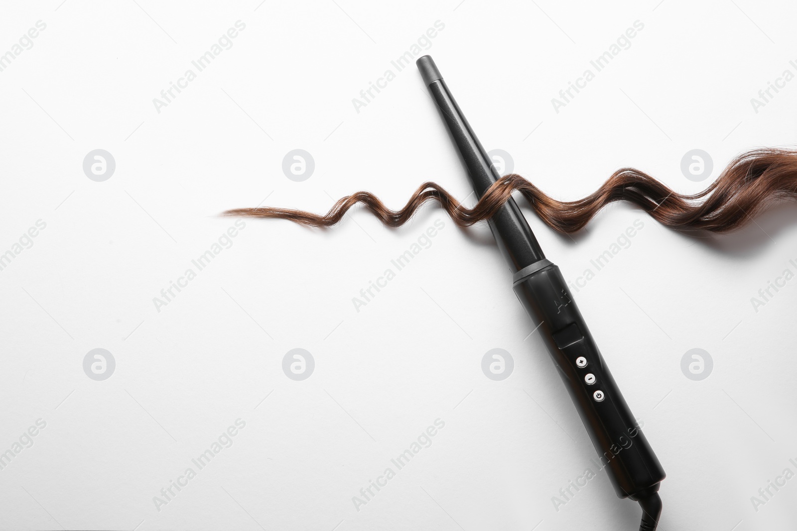 Photo of Modern clipless curling iron and brown hair lock on white background