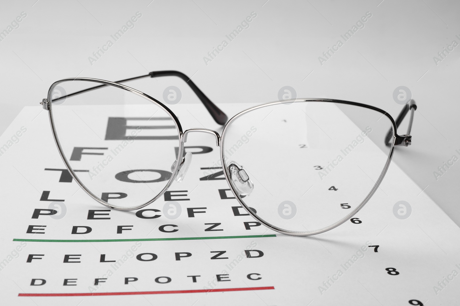 Photo of Glasses and vision test chart isolated on white