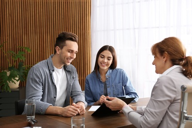 Photo of Lawyer having meeting with young couple in office