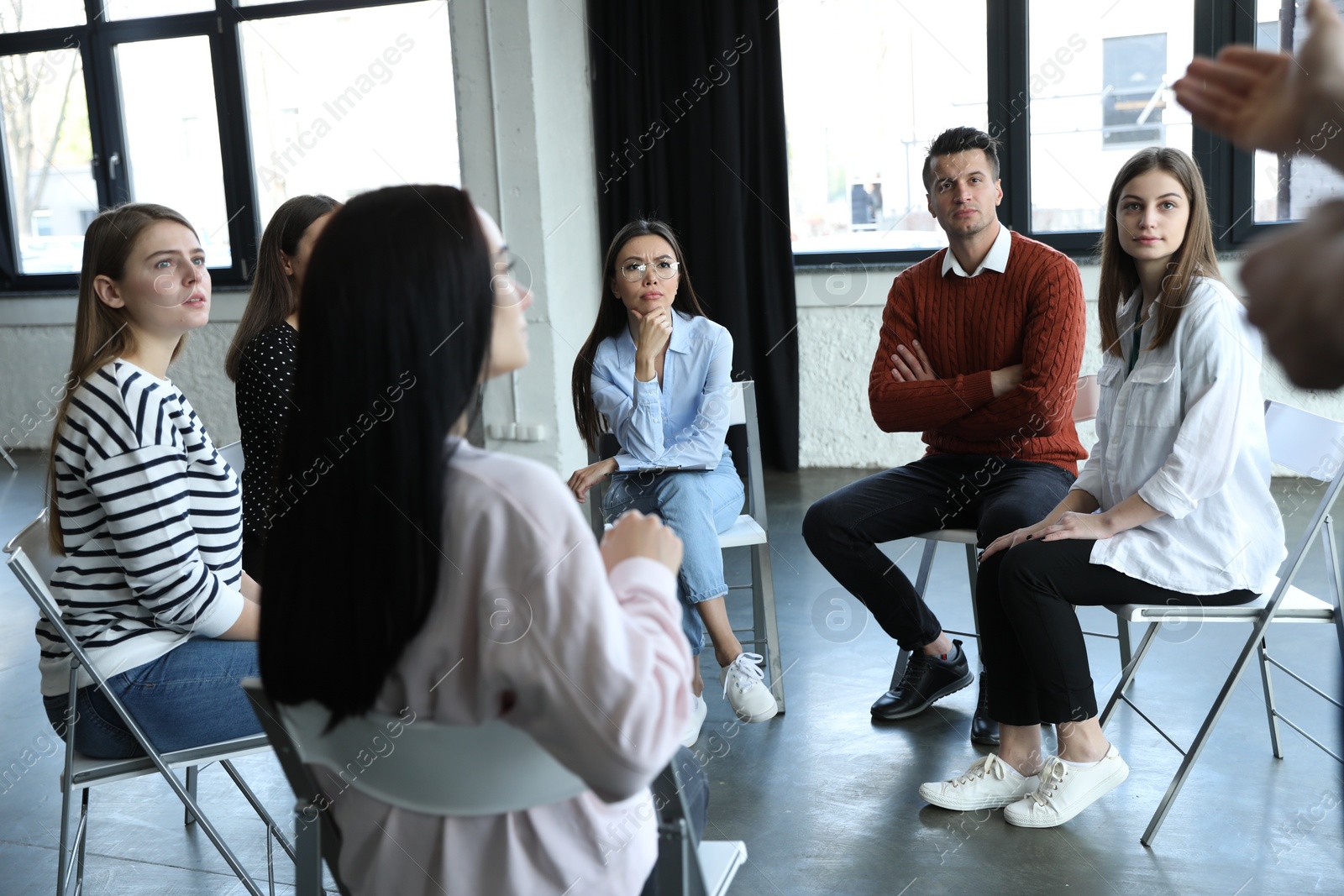 Photo of Psychotherapist working with patients in group therapy session indoors