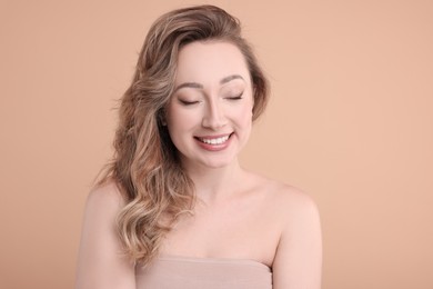 Portrait of smiling woman on beige background