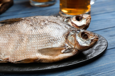 Tasty dried fish on blue wooden table, closeup