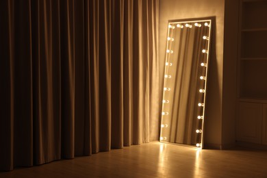 Photo of Modern mirror with light bulbs in makeup room