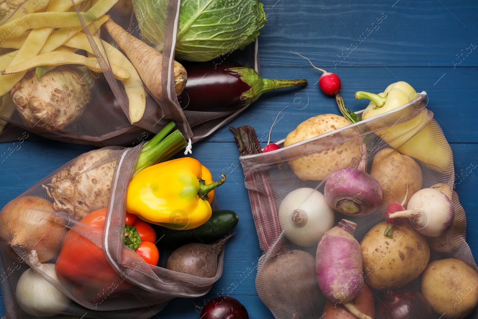 Photo of Different fresh ripe vegetables on blue wooden table, flat lay