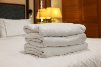 Photo of Stacked towels on bed in hotel room