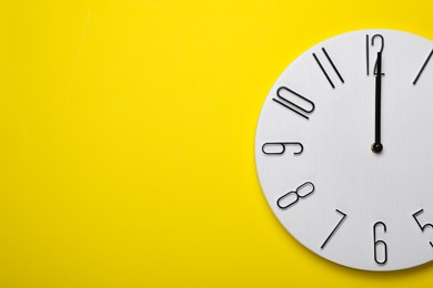 Photo of Modern clock on yellow background, top view. Space for text
