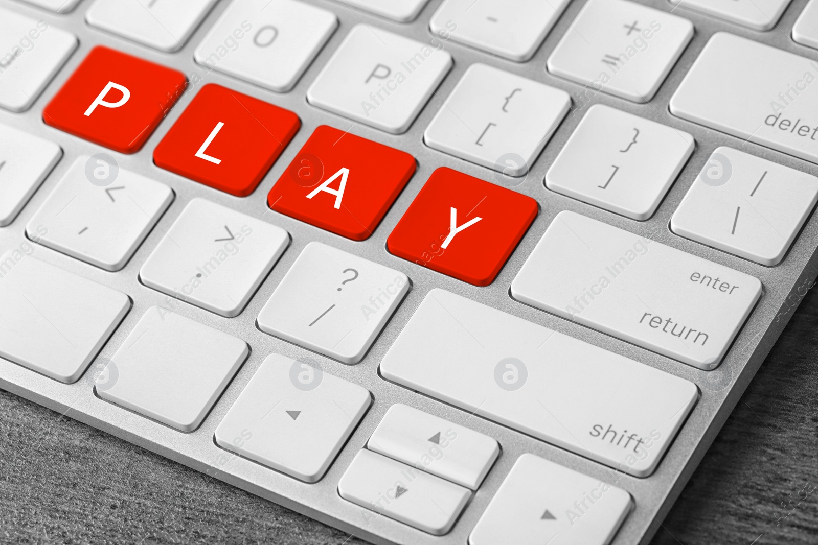 Image of Red buttons with letters P L A Y on keyboard, closeup