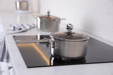 Photo of New clean pot on cooktop in kitchen