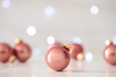 Beautiful Christmas ball on table against blurred festive lights. Space for text