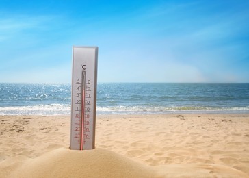 Image of Weather thermometer on sandy seashore, space for text