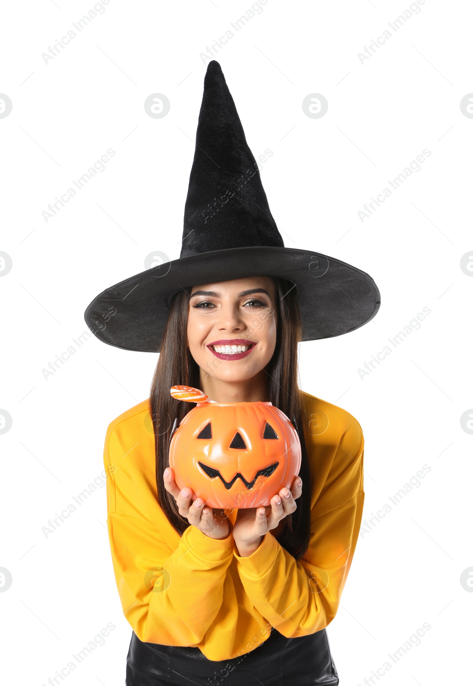 Photo of Beautiful woman wearing witch costume with Jack O'Lantern candy container for Halloween party on white background