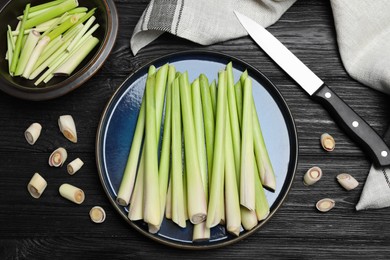 Photo of Flat lay composition with fresh lemongrass stalks on black wooden table