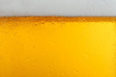 Photo of Glass of tasty beer with foam, closeup