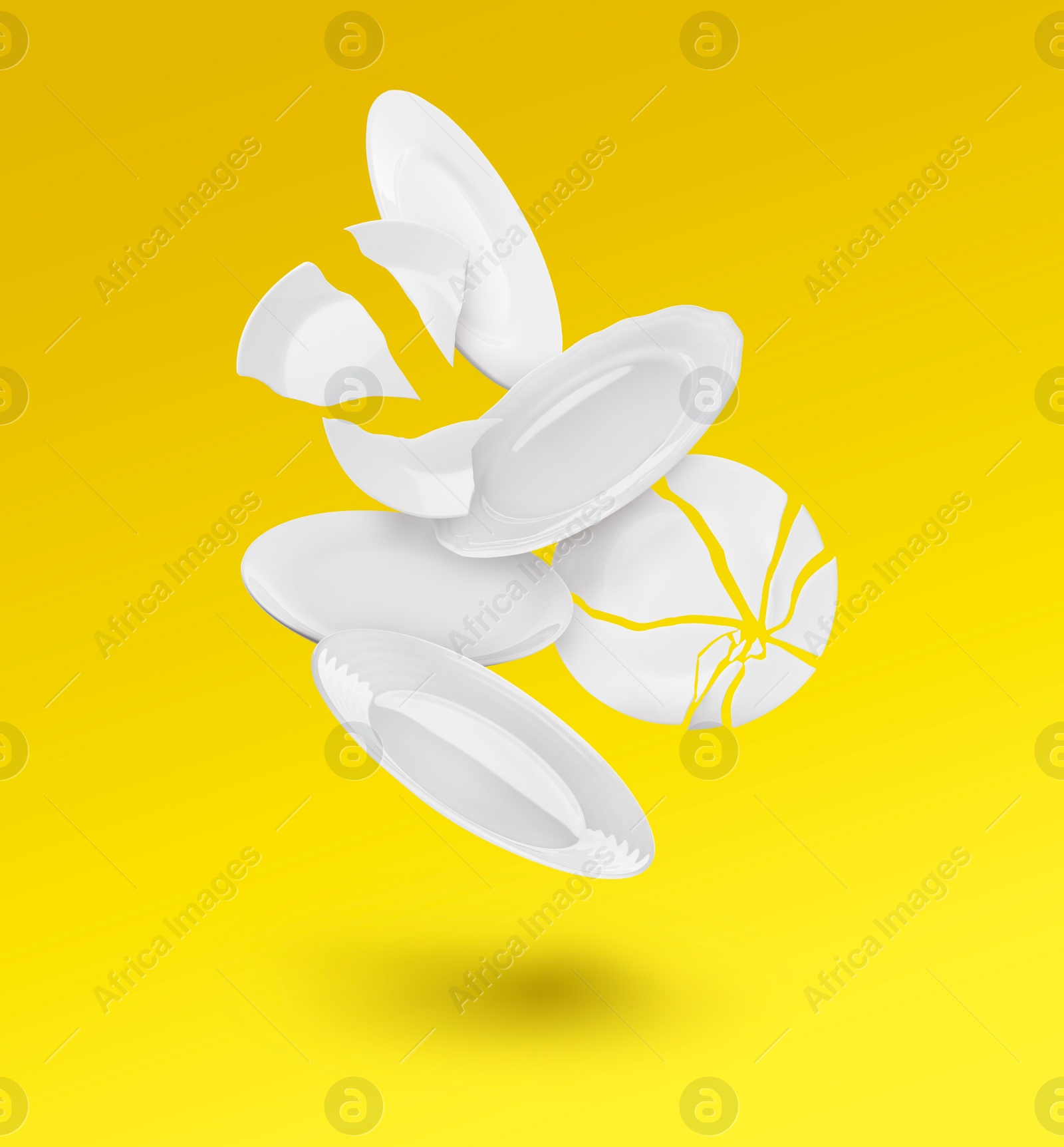 Image of Whole and broken plates falling on yellow background