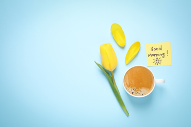 Delicious coffee, tulip and card with GOOD MORNING wish on light blue background, flat lay. Space for text