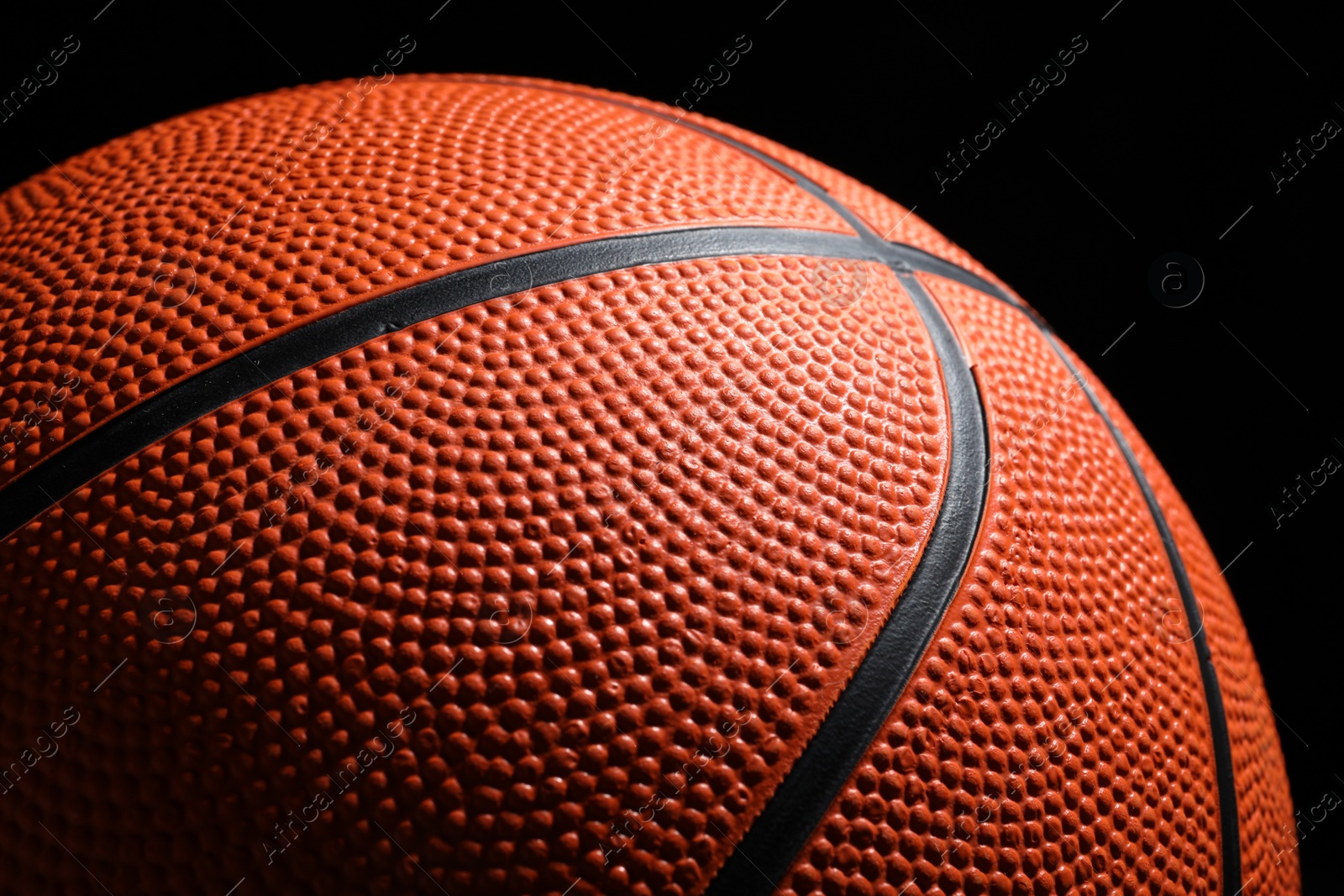 Photo of Orange basketball ball on black background, closeup