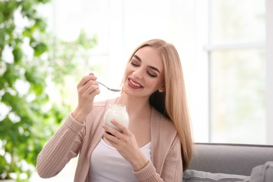 Young woman with yogurt indoors