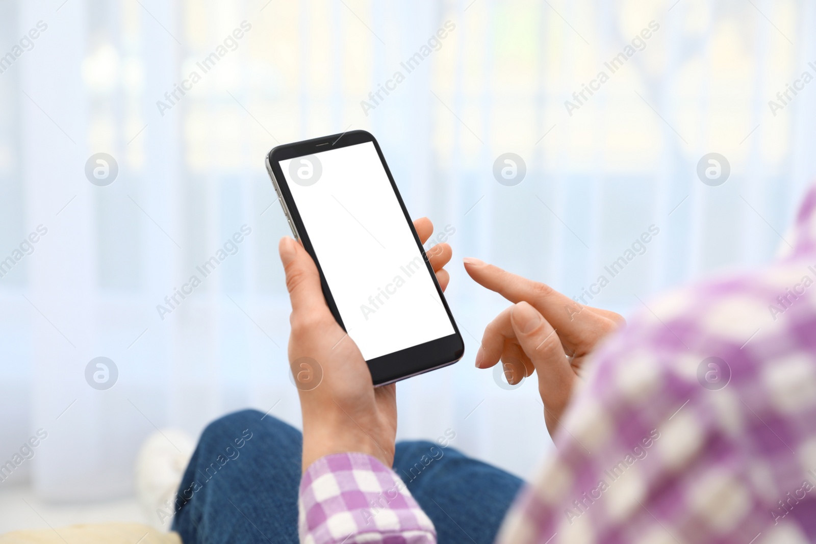 Photo of Woman holding smartphone with blank screen indoors, closeup of hands. Space for text