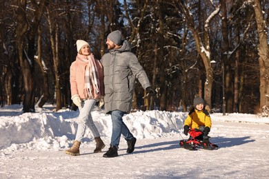 Happy family walking in sunny snowy park