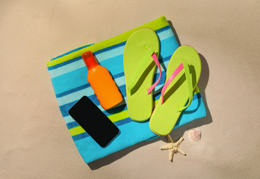 Photo of Flat lay composition with modern smartphone and beach objects on sand