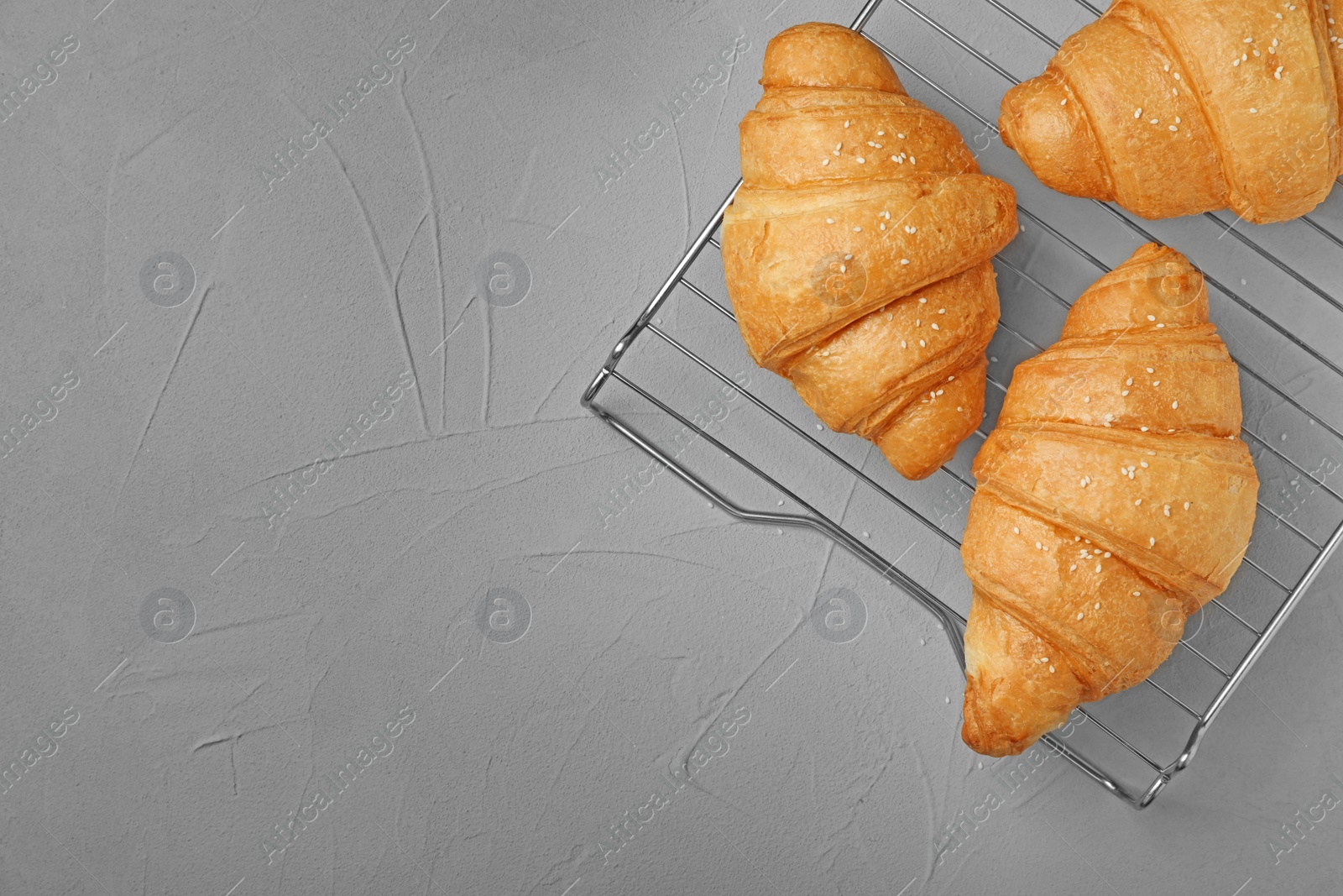 Photo of Tasty croissants on gray background, top view