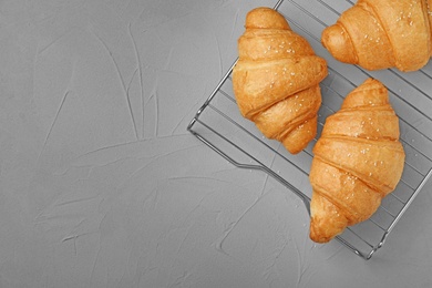 Photo of Tasty croissants on gray background, top view