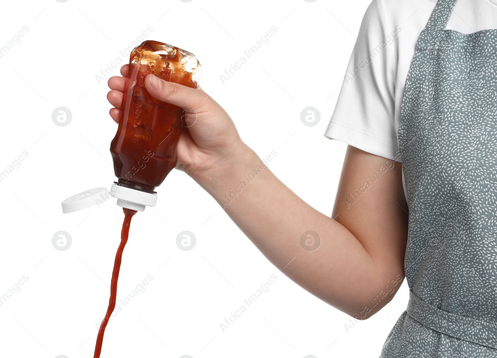 Photo of Woman pouring tasty ketchup from bottle on white background, closeup