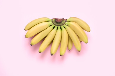 Photo of Bunch of ripe baby bananas on pink background, top view