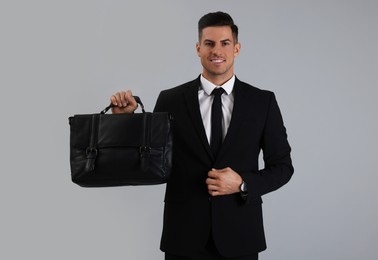 Photo of Businessman with stylish leather briefcase on light grey background
