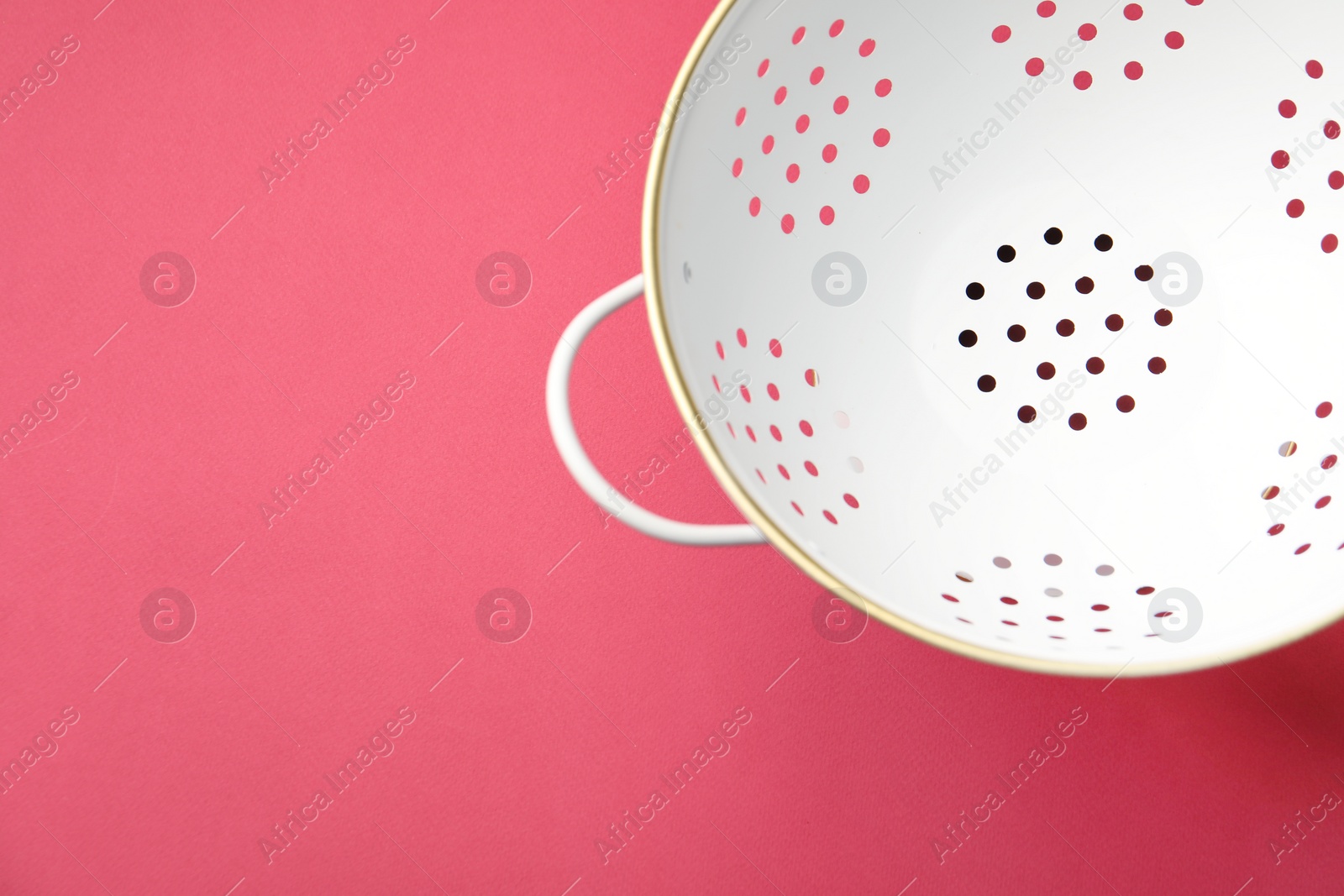 Photo of One clean empty colander on pink table, top view. Space for text