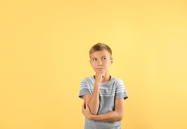 Photo of Adorable little boy in casual clothes on color background