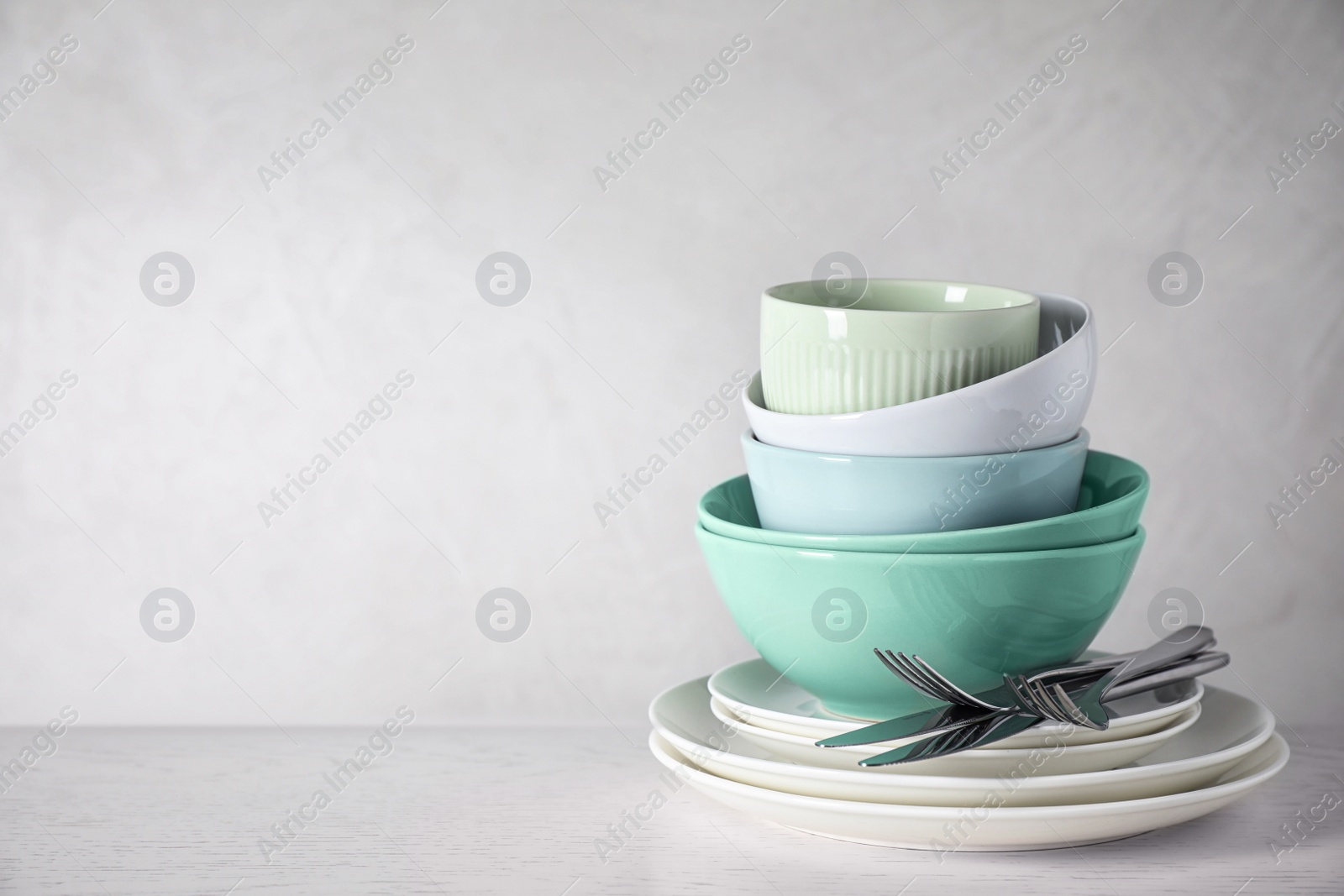 Photo of Set of clean dishware on white table. Space for text