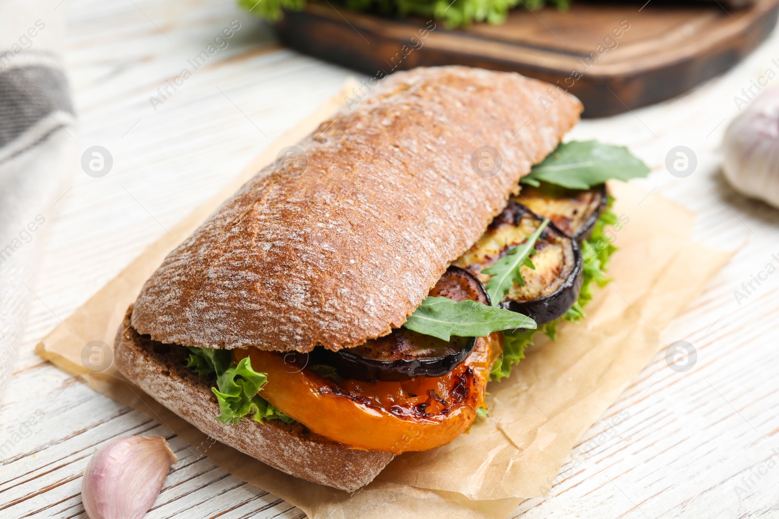 Photo of Delicious eggplant sandwich on white wooden table