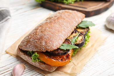 Photo of Delicious eggplant sandwich on white wooden table