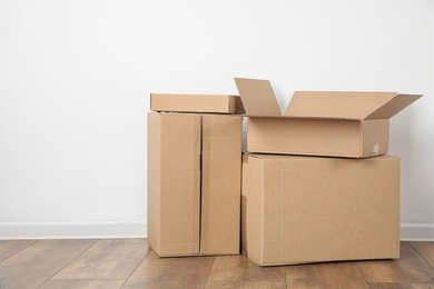 Photo of Pile of cardboard boxes near white wall indoors