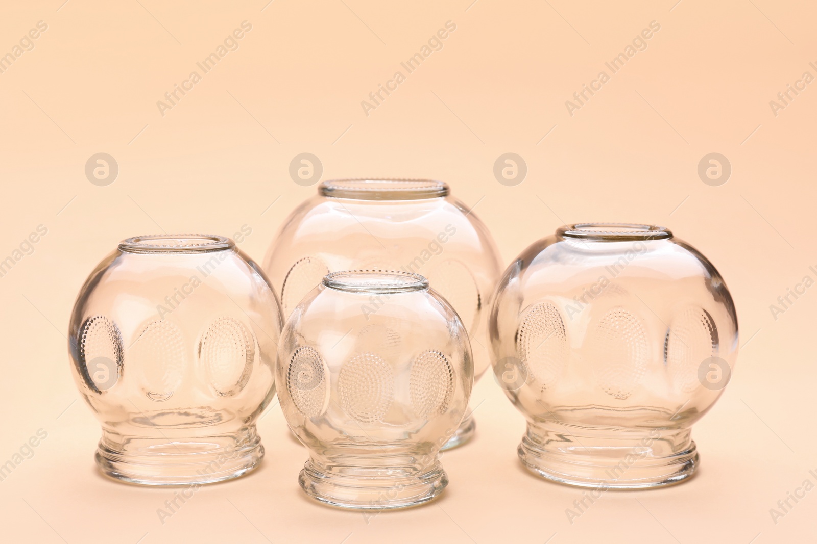 Photo of Glass cups on light coral background. Cupping therapy