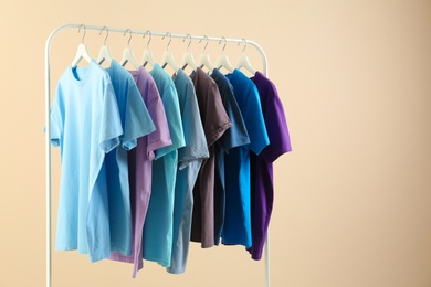 Photo of Men's clothes hanging on wardrobe rack against light background
