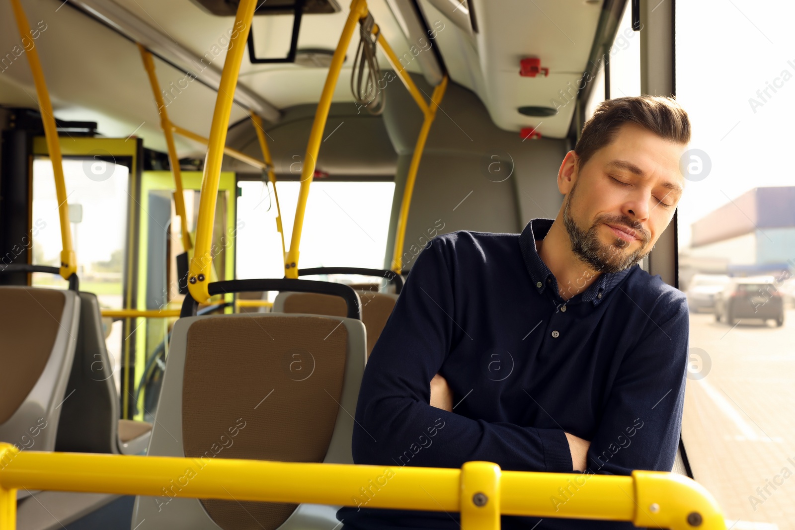 Photo of Tired man sleeping while sitting in public transport