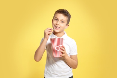 Photo of Boy with popcorn during cinema show on color background