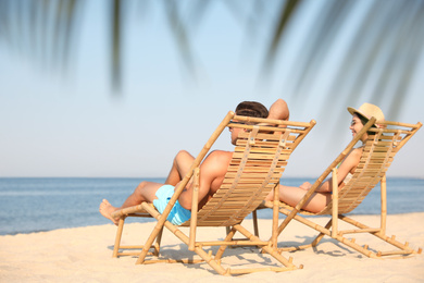 Couple resting on sunny beach at resort