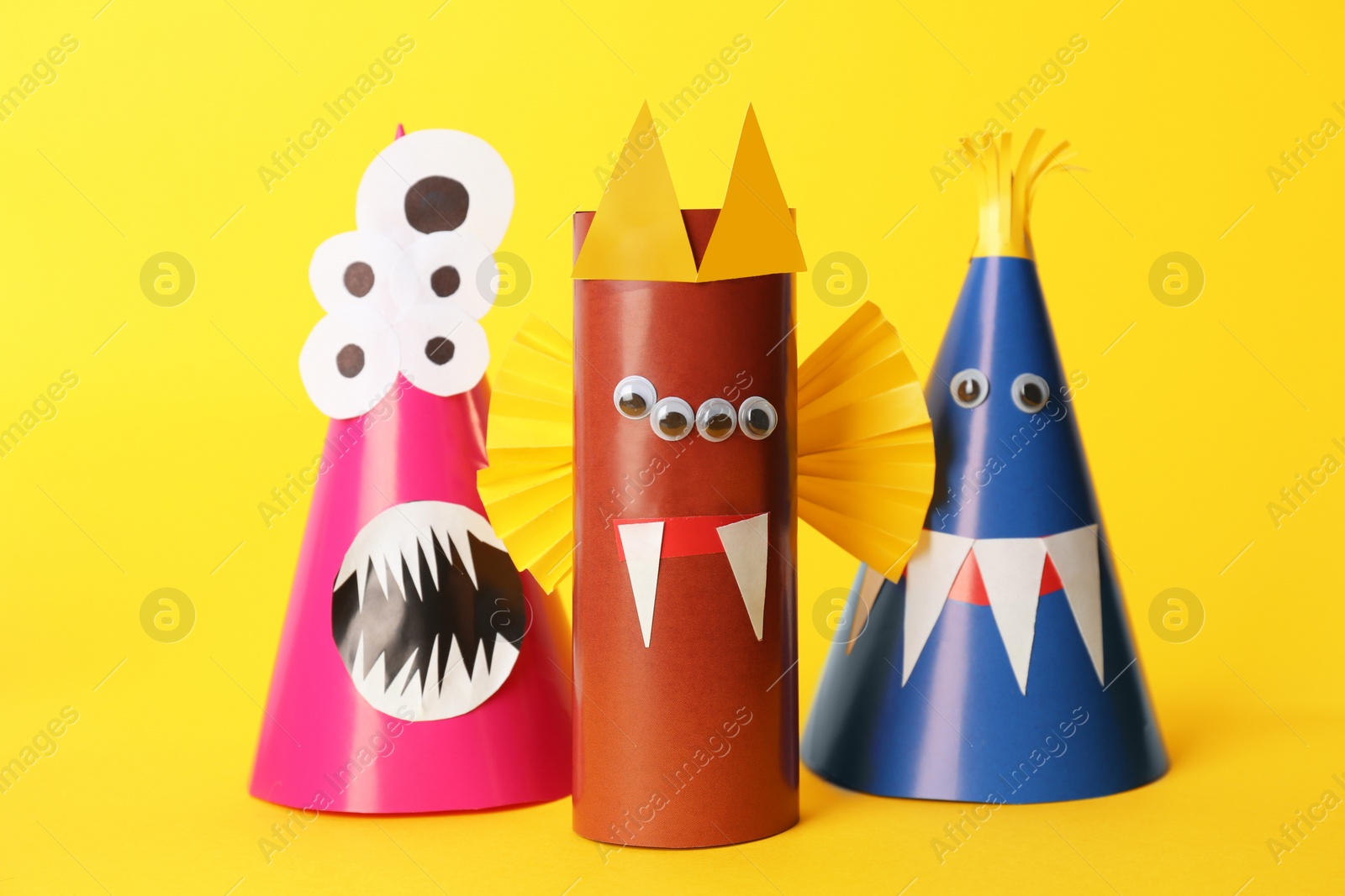 Photo of Funny monsters on yellow background. Halloween decoration