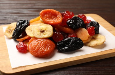 Photo of Mix of delicious dried fruits on wooden table, closeup