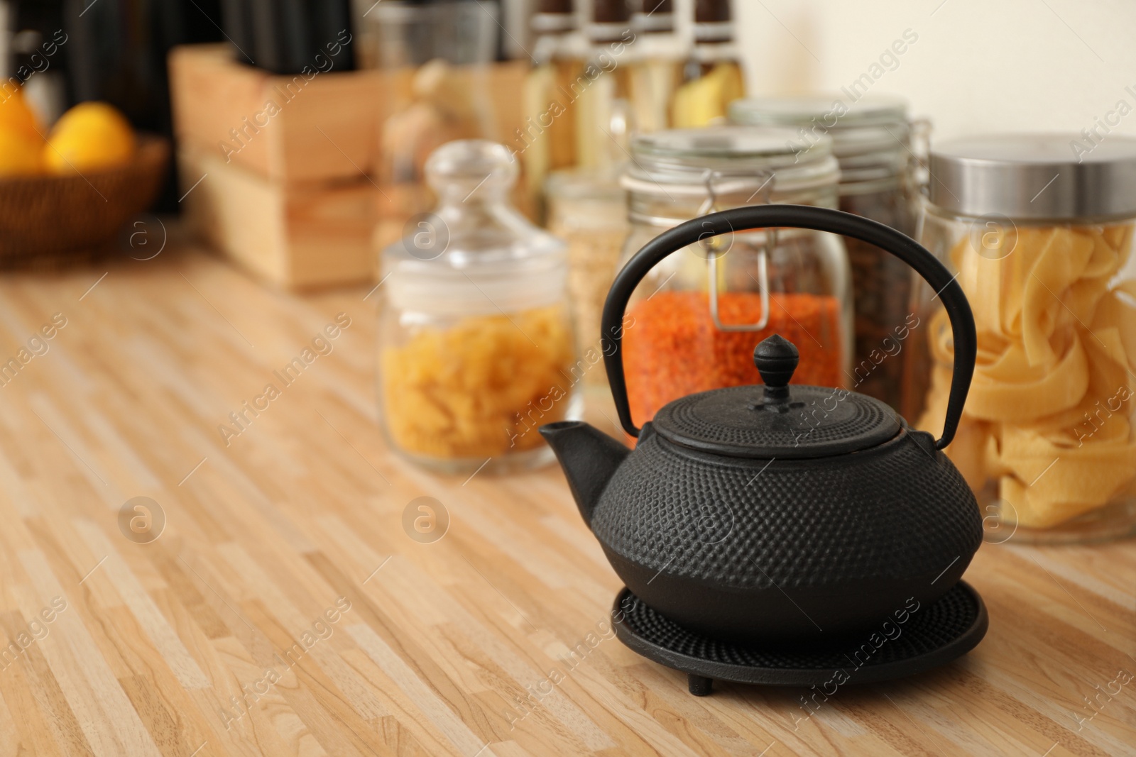 Photo of Black teapot on wooden countertop in kitchen, space for text. Interior element