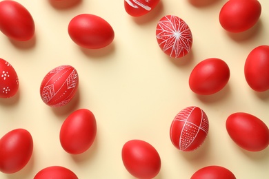 Flat lay composition of red painted Easter eggs on color background, space for text