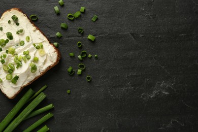 Delicious sandwich with cream cheese and chives on black table, flat lay. Space for text