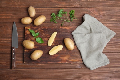 Flat lay composition with fresh organic potatoes on wooden background