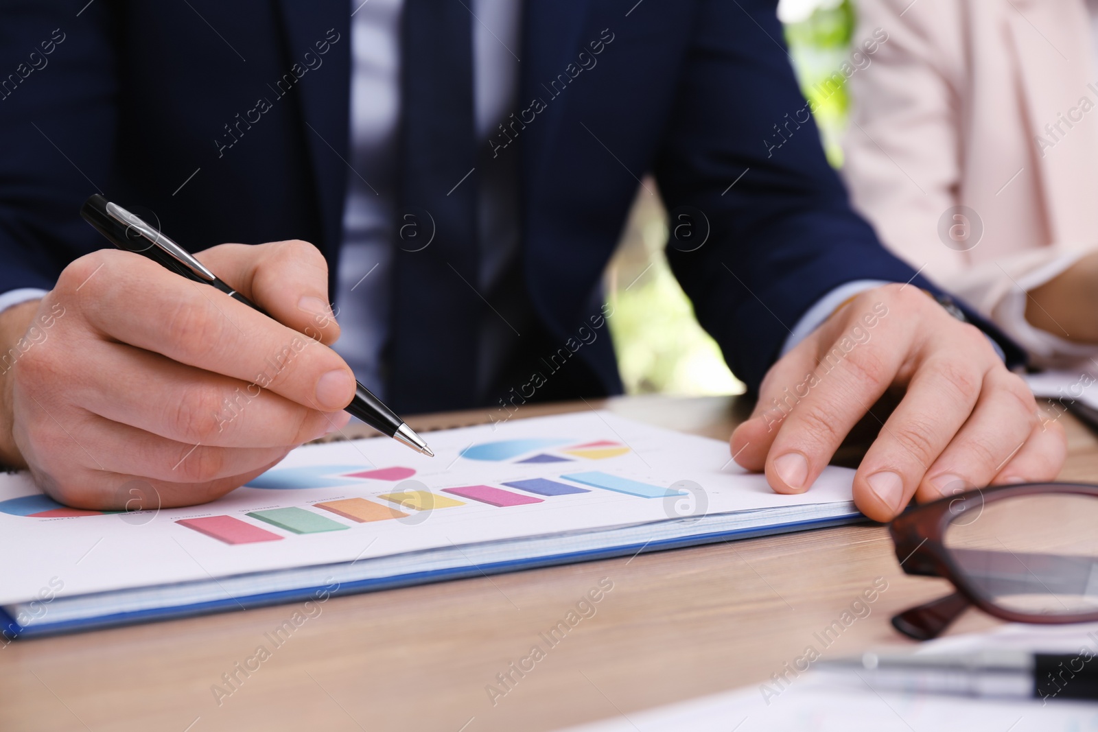 Photo of Business people working with charts and graphs at table in office, closeup. Investment analysis