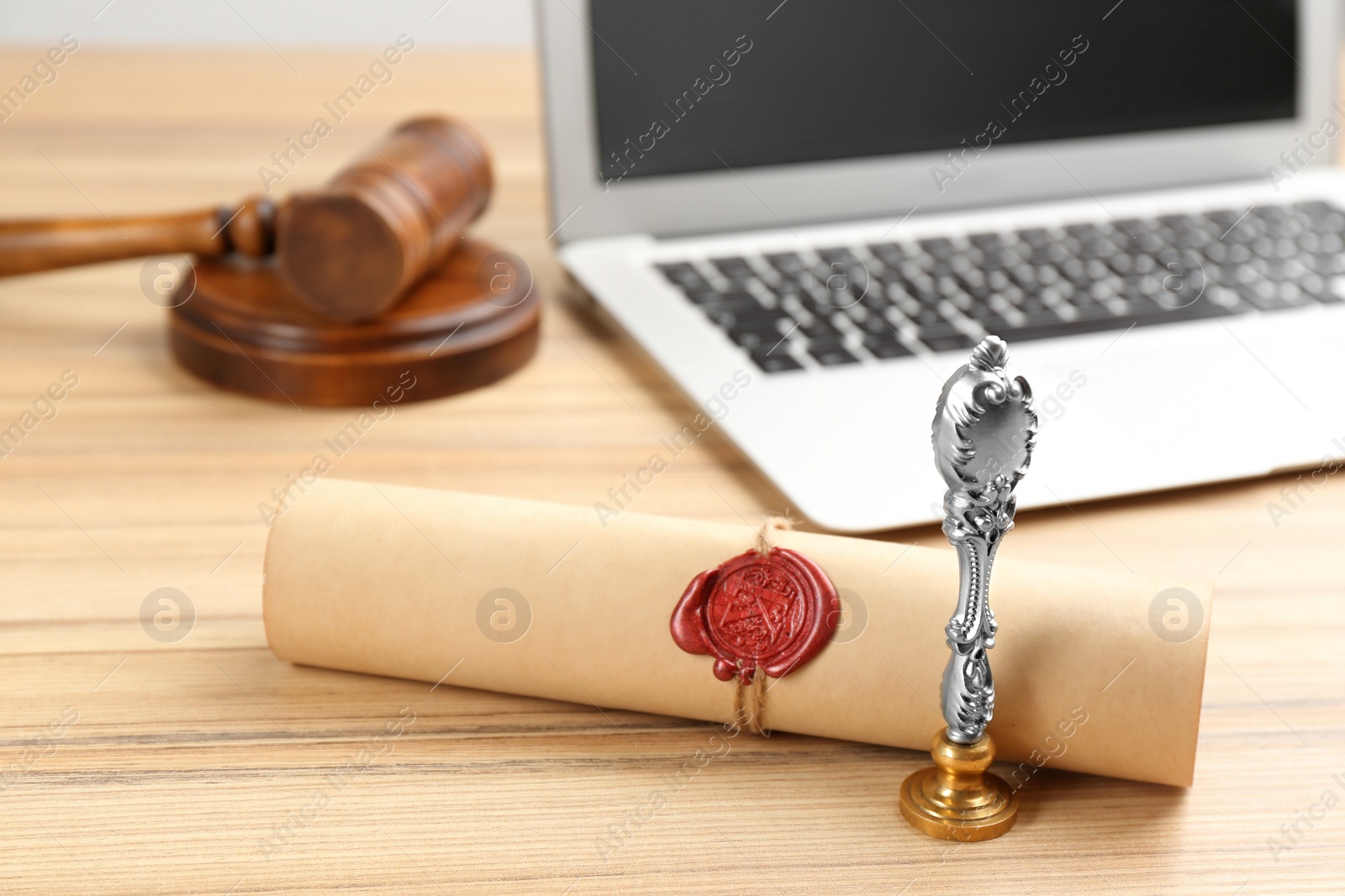 Photo of Notary's public pen and sealed document near laptop on wooden table