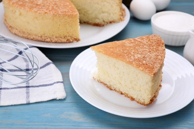 Piece of tasty sponge cake on light blue wooden table