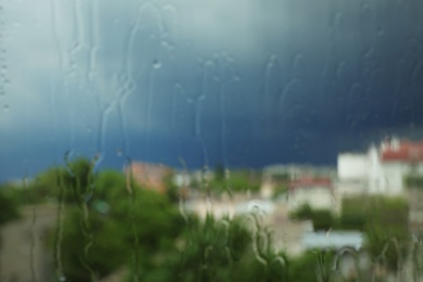 Photo of Blurred city view from window on rainy day